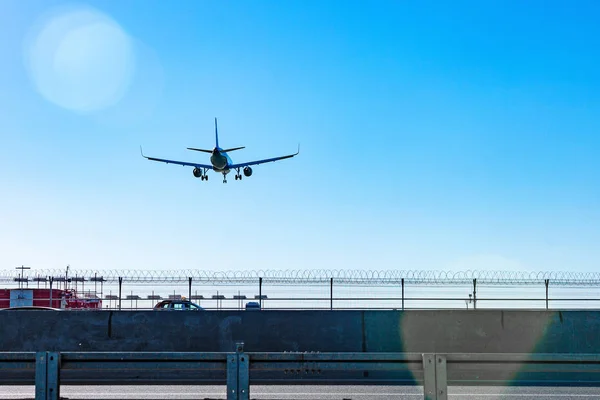 Passagiersvliegtuig vliegen in de blauwe hemel in zonlicht stralen — Stockfoto