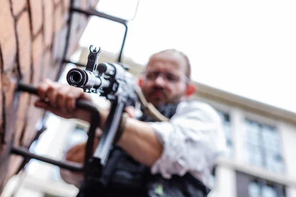 Potężny mężczyzna trzyma pistolet. Stylu filmu akcji wojny — Zdjęcie stockowe