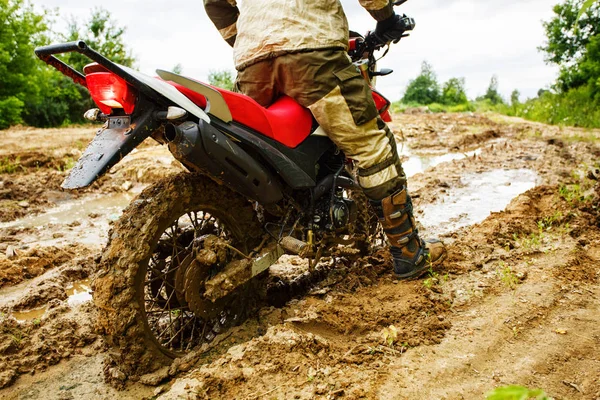 The man on a motorcycle rides through the mud