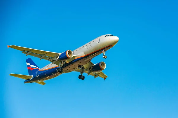 Passagiersvliegtuig vliegen in de blauwe hemel in zonlicht stralen — Stockfoto