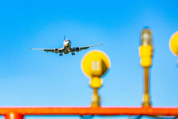 Passagiersvliegtuig vliegen in de blauwe hemel in zonlicht stralen — Stockfoto