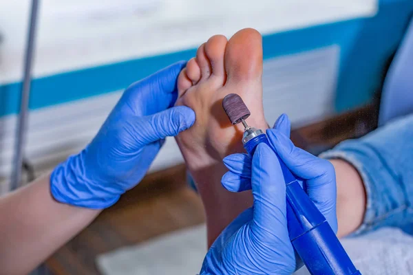 Meester tijdens een pedicure. Het proces van professionele pedicures. De tovenaar in het masker zorgt ervoor dat de gel naar de nagels met een borstel. Het concept van schoonheid en gezondheid — Stockfoto