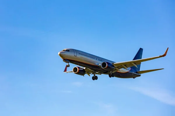 Passagiersvliegtuig vliegen in de blauwe hemel in zonlicht stralen — Stockfoto