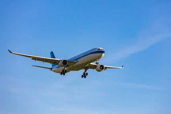Passagiersvliegtuig vliegen in de blauwe hemel in zonlicht stralen — Stockfoto