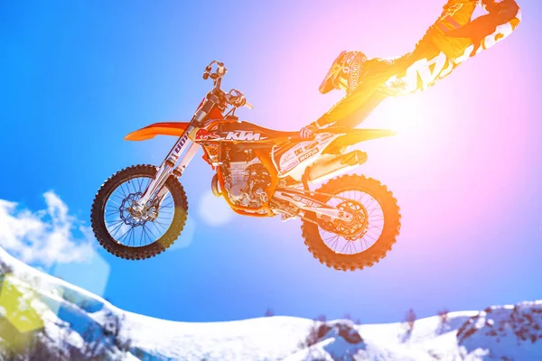 05.04.2018 Sochi, Rusia, Corredor en una motocicleta en vuelo, salta y despega en un trampolín contra las montañas nevadas — Foto de Stock