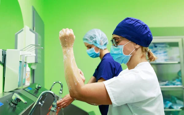 Хирурги в больнице моют руки — стоковое фото