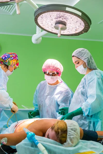 Cirugía de liposucción cosmética en quirófano real, grupo de cirujanos que trabajan con cánula —  Fotos de Stock