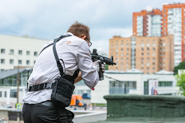 Muž na sobě neprůstřelnou vestu, košili v jeho krvi, vykonává oběť se zbraní akční film styl — Stock fotografie