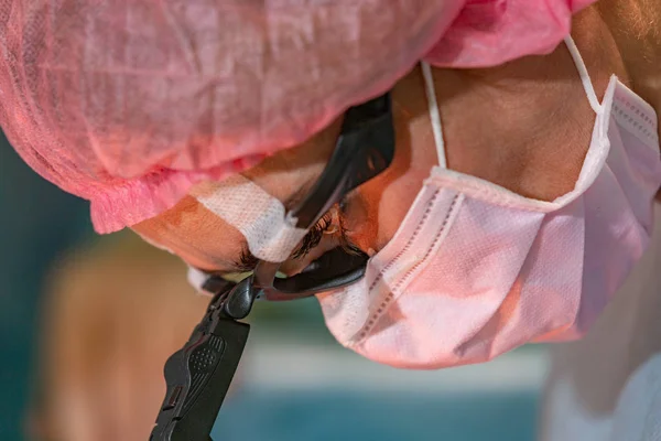 Médica cirurgiã ou estagiária usando máscara protetora e chapéu . — Fotografia de Stock