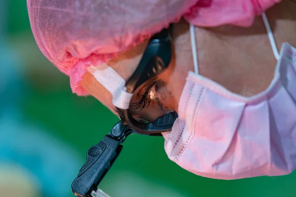 Médica cirurgiã ou estagiária usando máscara protetora e chapéu . — Fotografia de Stock