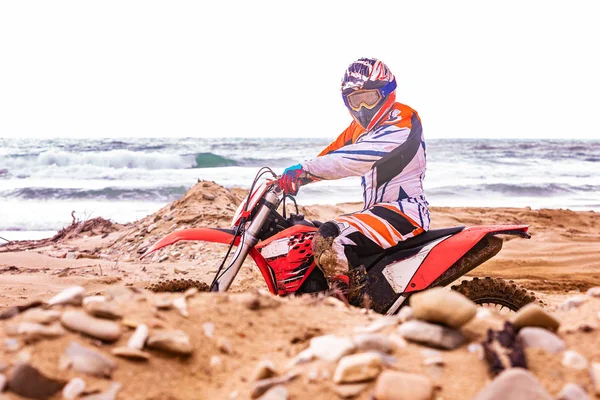Motorradfahrer im Schutzanzug sitzt auf Motorrad vor dem Meer — Stockfoto