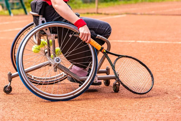Jeune femme handicapée en fauteuil roulant jouant au tennis sur un court de tennis . — Photo