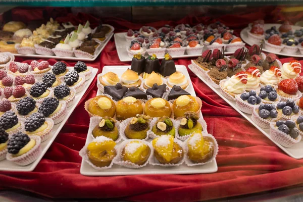 Different colorful Tasty beautiful cakes on a show-window in caf — Stock Photo, Image