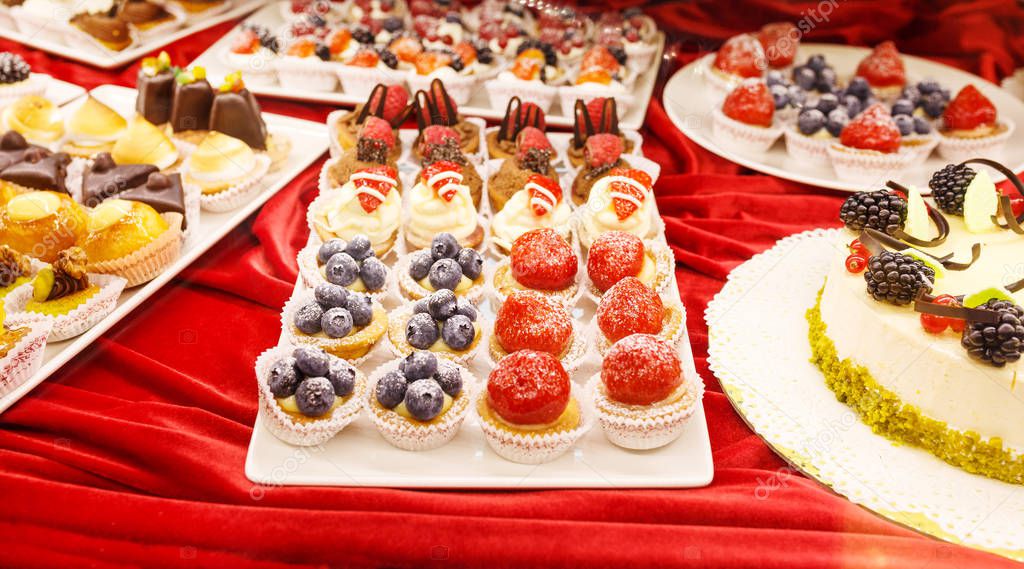 Different colorful Tasty beautiful cakes on a show-window in caf