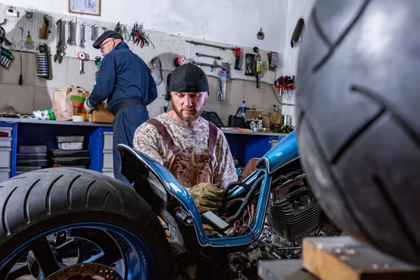 Side view porträtt av man arbetar i garaget reparation motorcykel — Stockfoto