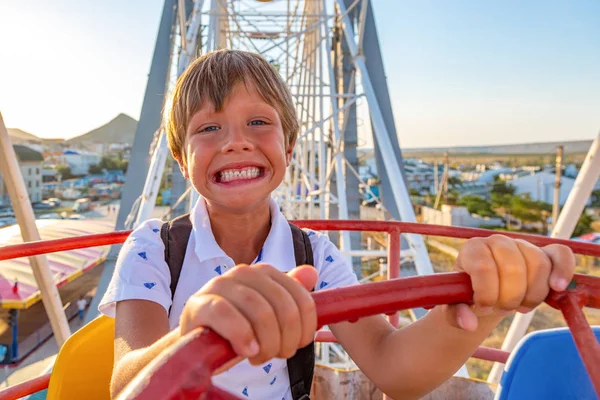 Smilling opgewonden jongen genieten van het uitzicht vanuit het reuzenrad in attractiepark — Stockfoto