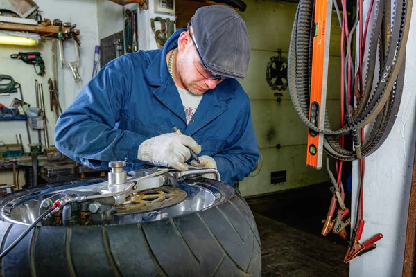 man repairing motorcycle tire with repair kit, Tire plug repair kit for tubeless tires.