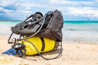 Equipment of a scuba diver, an oxygen balloon lies on the beach. Diving, equipment, fins, balloons, masks clipart