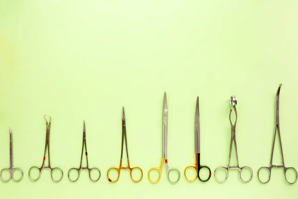 Medische apparatuur met inbegrip van chirurgische instrumenten op een groene achtergrond. bovenaanzicht, kopie spase — Stockfoto