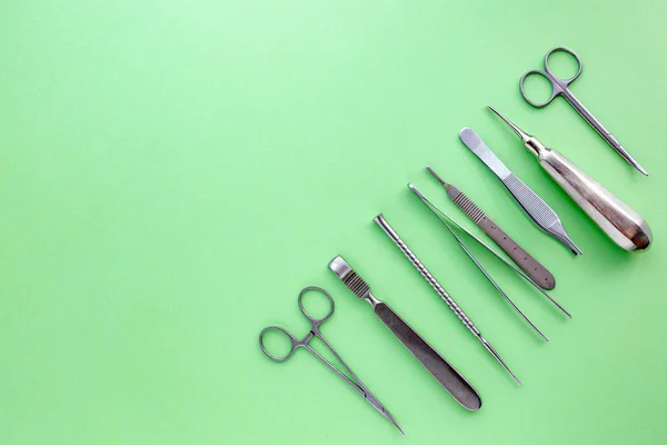 Medische apparatuur met inbegrip van chirurgische instrumenten op een groene achtergrond. bovenaanzicht, kopie spase — Stockfoto