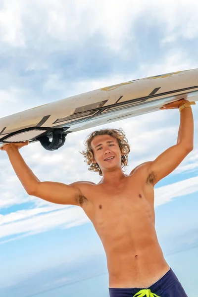 Hombre guapo caminar con la tabla blanca de surf en blanco esperar a que las olas para surfear lugar en la orilla del mar océano. Concepto de deporte, fitness, libertad, felicidad, nueva vida moderna, hipster . — Foto de Stock