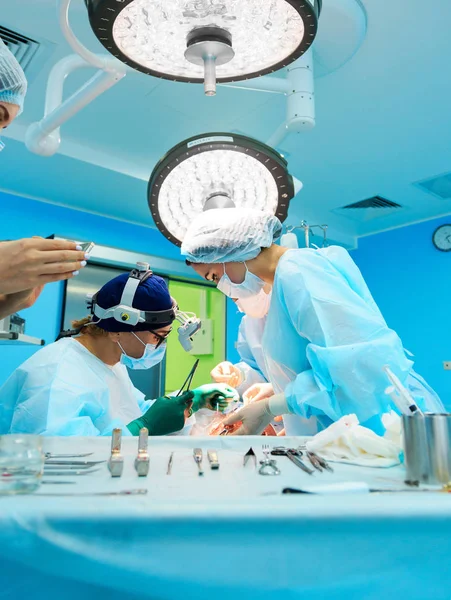 Surgical tools lying on table in surgical theatre. Steel medical instruments ready to be used. Surgery and emergency concept