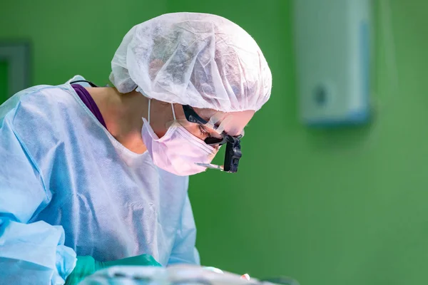 Işlem sırasında koruyucu maske ve şapka giyen kadın cerrah doktor. Sağlık, tıp eğitimi, Acil Tıp Servisi, cerrahi kavramı. — Stok fotoğraf