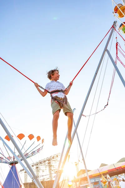Opgewonden jongen smilling springen op een trampoline met verzekering. — Stockfoto
