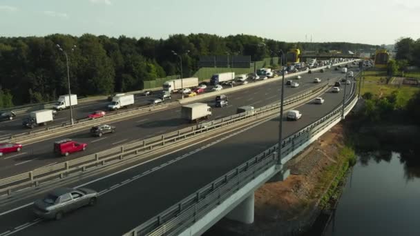 Letecká drone scéně ze silnice na venkově. Kamera se pohybuje po silnici. Pohled shora z auta a nákladní automobily, jízdní vysokou cestou na mostě. — Stock video