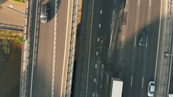 Повітряний безпілотник сцени шосе в сільській місцевості. Камера рухається вздовж дороги. Вид зверху на автомобіль і вантажівки, що рухаються по дорозі з переходом — стокове відео