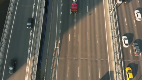 Aerial drone scene of highway in the countryside. Camera moves along the road. Top view of the car and trucks driving along the high road with junction — Stock Video