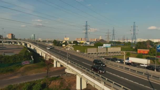 Drohnen-Szene einer Autobahn auf dem Land. Kamera bewegt sich entlang der Straße. Blick von oben auf die Auto- und Lastkraftwagen, die auf der Hochstraße mit Kreuzung fahren — Stockvideo