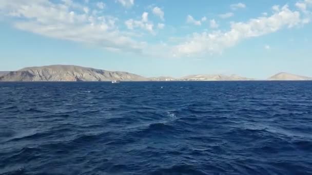 Fartyg flyttar på det vågor havet mot en bakgrund av berg. Svarta havet på bakgrunden av kust och stränder. — Stockvideo