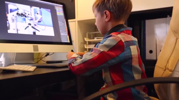 Smart Boy trabaja en un proyecto para su computadora. Boy trabaja en el ordenador usando una tableta gráfica — Vídeos de Stock