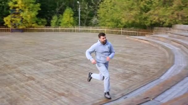 Człowiek działa w dół i następnie górę schodami w parku. człowiek, bieganie po schodach w parku. — Wideo stockowe