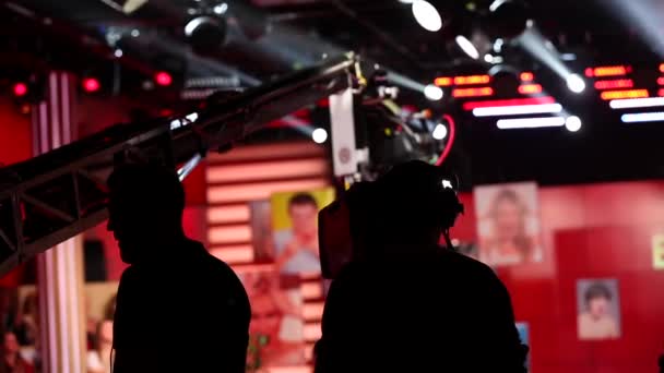 Operator met videocamera schieten, operator met videocamera en film bemanning in bijna donkere kamer schieten talkshow — Stockvideo