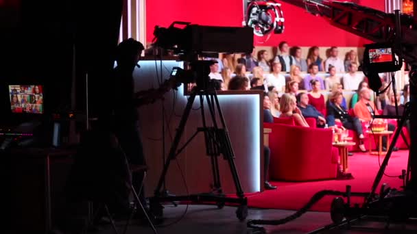 Operatore con videocamera riprese, operatore con videocamera e troupe di film in sala quasi buia riprese talk show — Video Stock