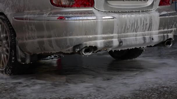 Vatten och schampo som läcker från en bil i en biltvätt — Stockvideo