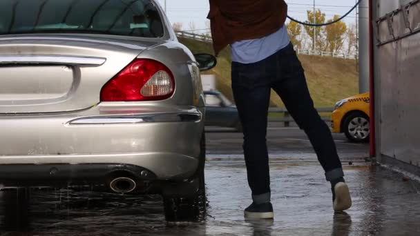 Man tvättar sin bil med vattendimma från högtryckstvätt. Biltvätt självbetjäning. — Stockvideo