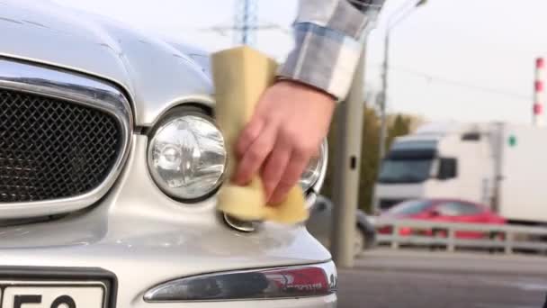 Homme laver soigneusement sa voiture préférée avec de l'éponge. Lavage auto self-service — Video