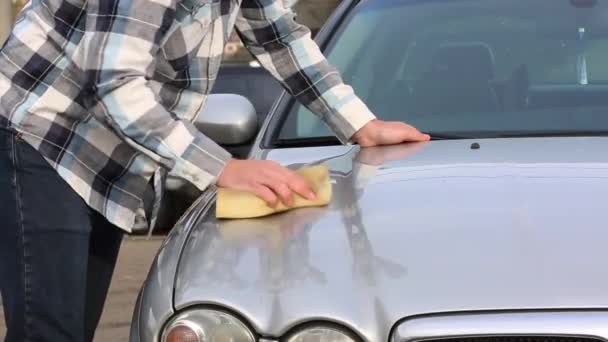Ο άνθρωπος πλένετε προσεκτικά το αγαπημένο αυτοκίνητό του με σφουγγάρι. Car wash, self service — Αρχείο Βίντεο