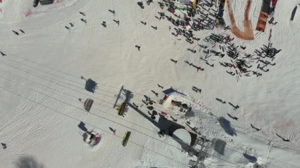 Telesilla en una estación de esquí en un clima claro y frío. Vista aérea. Estación de esquí. Esquiadores y snowboarders suben el telesilla con montañas cubiertas de nieve — Vídeo de stock