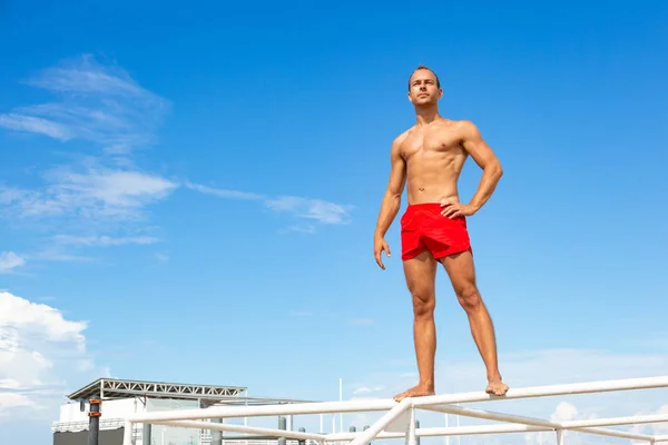 Handsome Athlete Shirtless Young Man stands on a rock against the sky — Stock Photo, Image