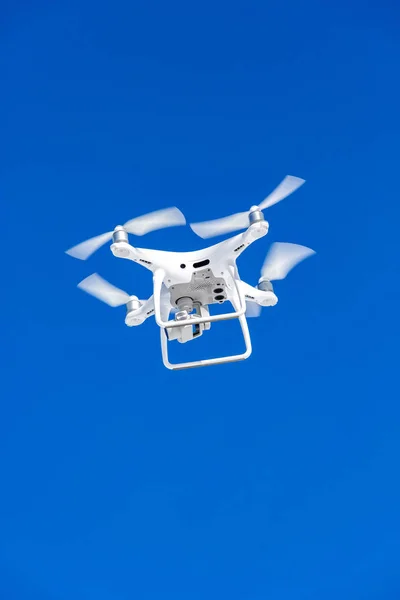 Quadcopter drone with the camera against the blue sky