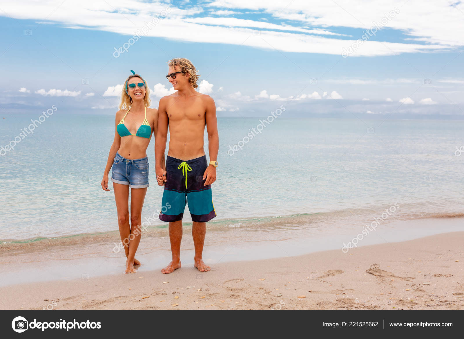 Portrait of young couple in love embracing at beach and enjoying time