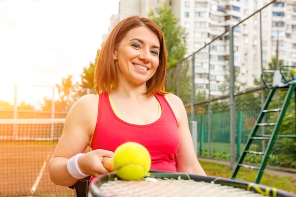 Joven discapacitada en silla de ruedas jugando tenis en pista de tenis . — Foto de Stock