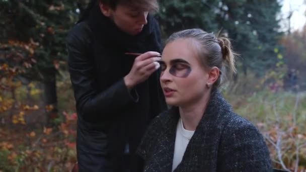 Vizážista a stylista dělá make-up modelu pro Halloween. — Stock video