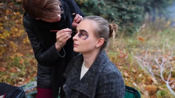 Vizážista a stylista dělá make-up modelu pro Halloween. — Stock video