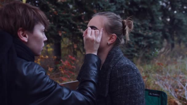 Visagist en stylist doen make-up model voor Halloween. — Stockvideo