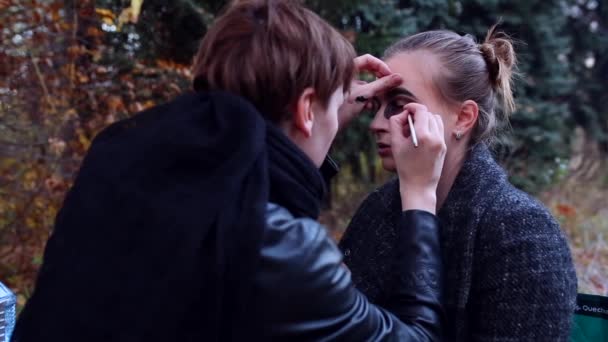 Visagist en stylist doen make-up model voor Halloween. — Stockvideo